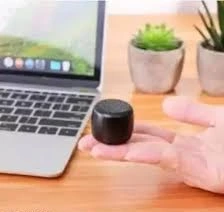 person holds Nano Boom next to laptop